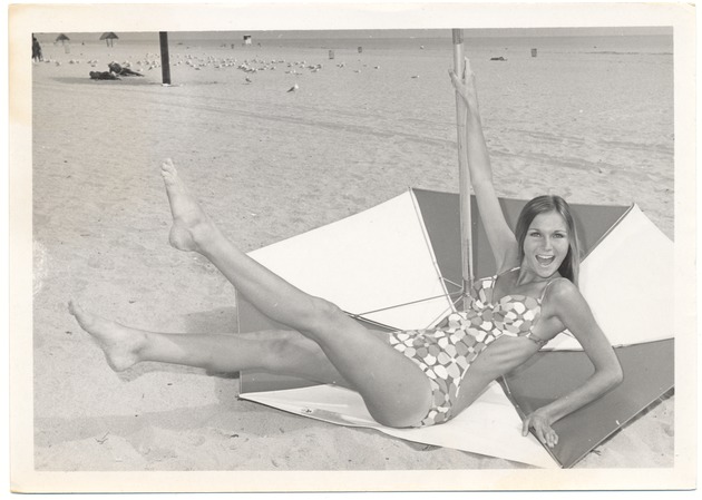 Dominique Doherty laying down next to an umbrella - 