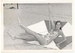 Dominique Doherty laying down next to an umbrella