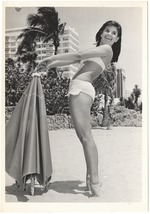 [1950/1959] Donna Rankin placing an umbrella in the ground