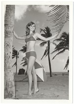 Melinda Brady between a palm tree's leaf and trunk