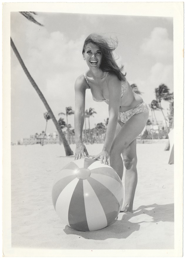 Elaine Richards beinding to pick up a beach ball - 