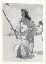 Elaine Richards beinding to pick up a beach ball