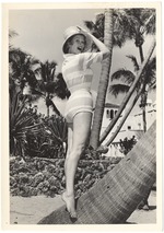 Joan Gordon holding her hat amongst many palms