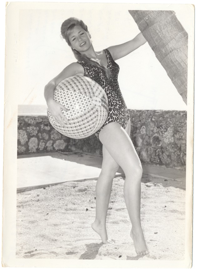 Karen Kirsch grabbing both a beach ball and a palm tree's trunk - 