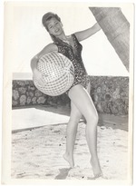 Karen Kirsch grabbing both a beach ball and a palm tree's trunk