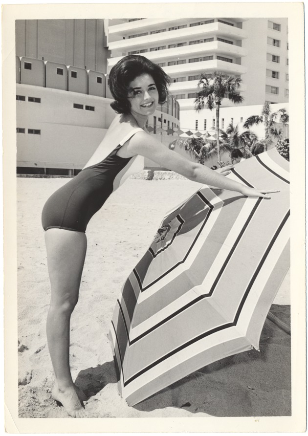 Carol Hale placing an umbrella in the sand - 