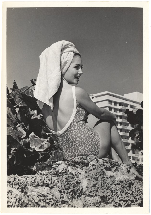 Sandy Steeves with a towel on her head sitting on coral rock - 
