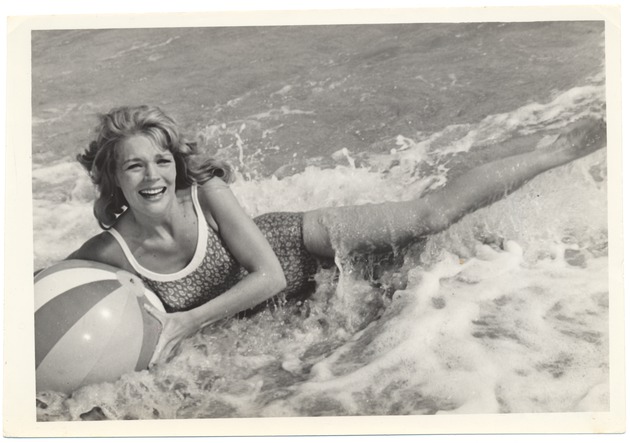 Diane Bernath holding onto a beach ball during a wave - 
