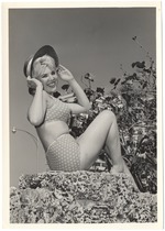 Melinie Smith wearing a beach hat on a coral rock wall