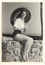 Sue Winters with a parasol on a coral rock