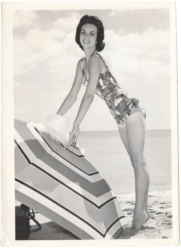Donna Joseph with a hat and an umbrella in the sand - 
