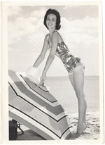 Donna Joseph with a hat and an umbrella in the sand