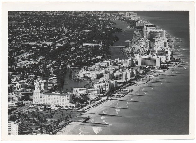 Promotional photographs, aerial views looking south on Miami Beach - Photograph, recto: [Aerial view looking north from over the ocean, Collins Park to North Beach. Roney Plaza, the Wofford, Algiers, Seville, Fontainebleau ca. 1960]