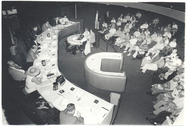 Miami Beach Commission meeting with Mayor Leonard Haber - Photograph, recto: [View of the Commission Chamber from the 2nd floor looking down. Attending the City Commission Meeting are City Clerk Elaine Mathews, City Attorney Joseph Arnold, Leonard Weinstein (center), Elayne Weisburd, Mayor Leonard Haber, City Manager Morris Lipp, and commissioners Philip Sahl, Joseph Malek, Mike Friedman among others]