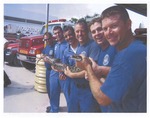 Fire fighters holding caught snake