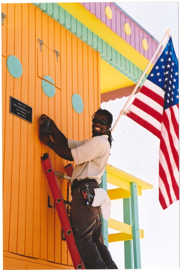Ed Cowart plaque installation on lifeguard stand, 2002 - Photograph, recto: [View of man installing the Guardstand plaque which reads "Built by and in Memory of Ed Cowart May 2002."]  