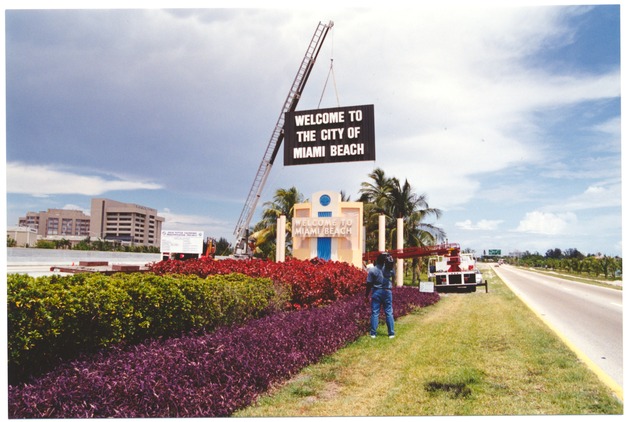 Miami Beach Welcome Sign - Photograph, recto: [View of the installation of sign of "Welcome to Miami Beach" on the Julia Tuttle causeway] 