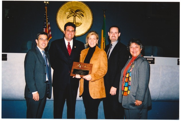 Miami Beach Commissioners and Mayor David Dermer presenting awards, November 13, 2002 - Photograph, recto: [Posed photograph of City Manager Jorge Gonzalez, Mayor David Dermer, Antoinette Zel, Commissioner Richard L. Steinberg, and Commissioner Matti Herrera Bower]