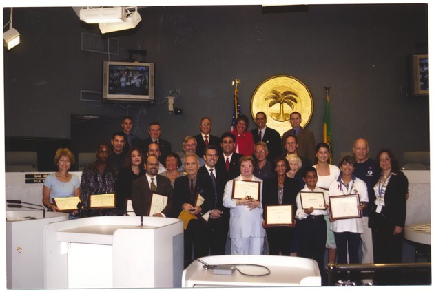 Miami Beach residents and city officials who participated in the Miami Beach Neighborhood Leadership Academy - Photograph, recto: [Mayor David Dermer and other city officials presenting Certificates Of Completion to Miami Beach residents who participated in The Miami Beach Neighborhood Leadership Academy]  