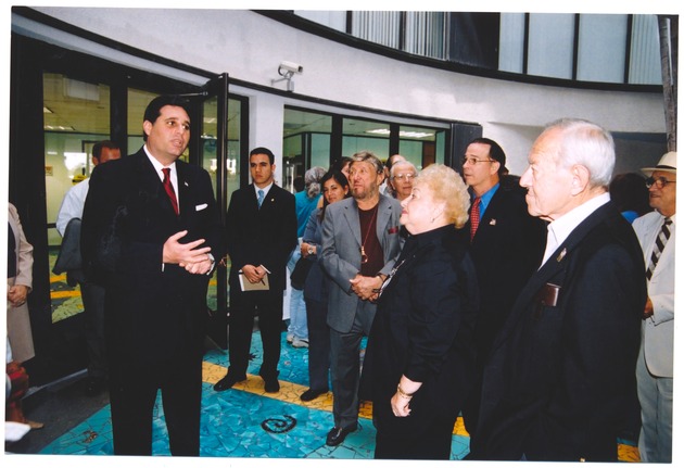 Miami Beach city officials during City's State of Address, Miami Beach's Anniversary, and rededication of City Hall, March 26, 2003 - Photograph, recto: [View of Mayor David Dermer speaking at the entrance of the Miami Beach City Hall, March 26 2013]