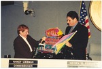 Commissioners Nancy Liebman and Neisen Kasdin holding a colorful beach chair and umbrella