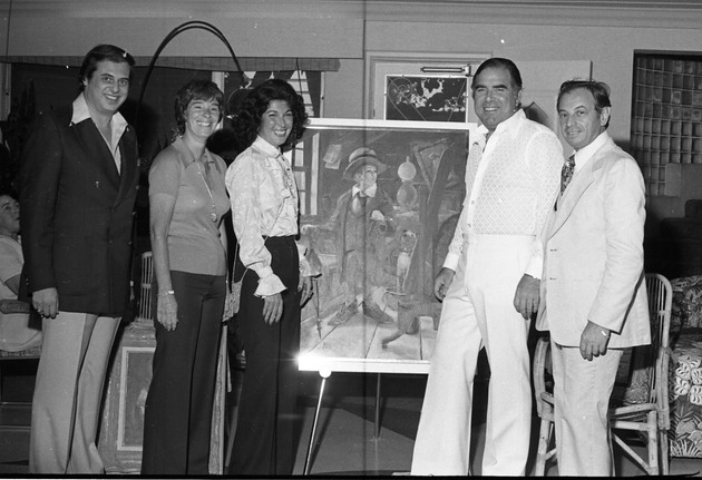 Miami Beach artists and city meetings and events, 1977 - Negative: [View of Leonard Haber by a painting with other individuals, possibly artists]
