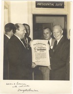 Photo of Dwight D. Eisenhower receiving an invitiation, standing in front of a Presidential Suite sign