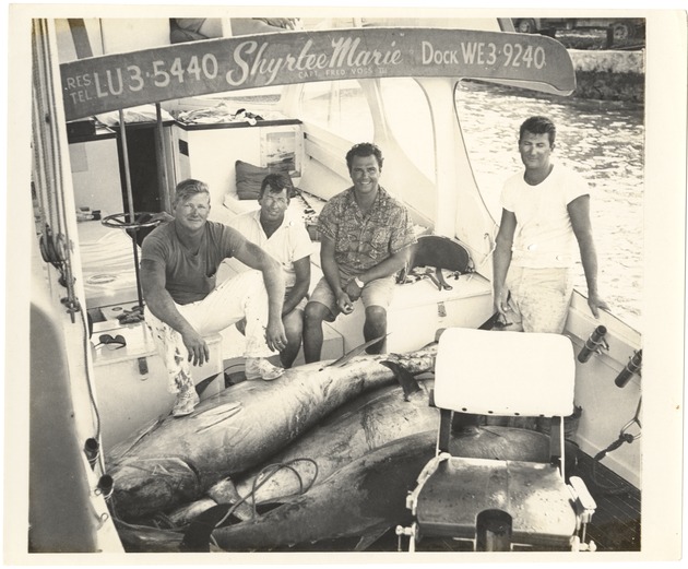 Four men on a fishing boat with their catch - Recto