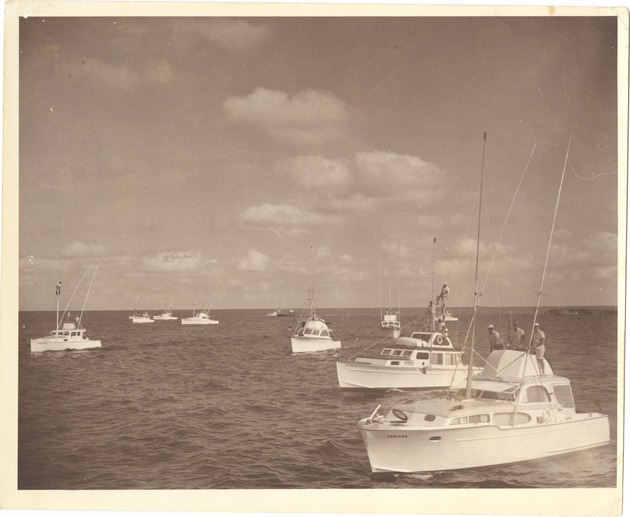 Several center console fishing boats on the ocean - Recto