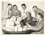 [1950] Photo of men looking at MacFadden Deauville postcards