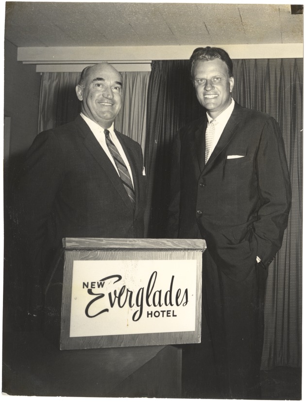 Two men at a podium in the Everglades Hotel - Recto