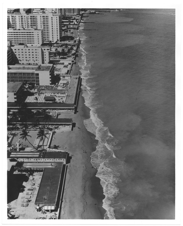 Aerial view of sandy area and buildings on the ocean front during high tide - Recto Photograph
