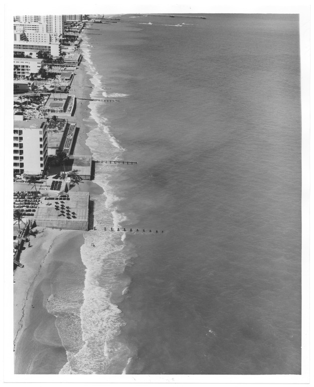 Aerial view of building and hotels on the ocean front during high tide - Recto Photograph