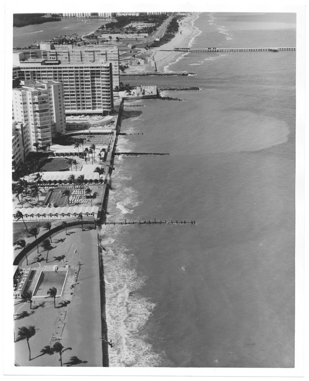 Aerial view of building and hotels on the ocean front during high tide - Recto Photograph
