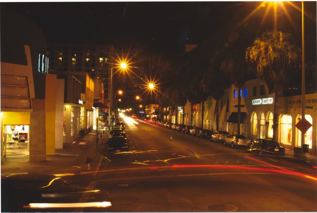 Streets and storefronts on Collins Avenue at night - 