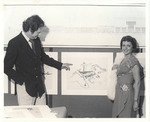 Unidentified man and woman displaying architectural drawings