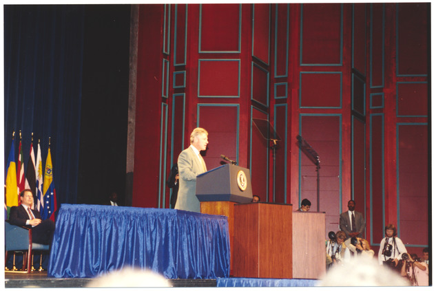 President Clinton on stage at a podium - Recto Photograph