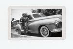 [1950/1959] Josephine Perez standing by Dodge Sedan