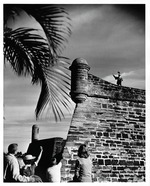 A family waves to a man re-enacting a Spanish colonial soldier on the walls of the terreplein of the Castillo de San Marcos, looking East, 1965