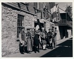Group in period clothing standing in front of the Rodriguez House, looking Northwest