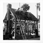 Construction of the Old Blacksmith Shop from Cuna Street, shingling the roof, looking Southeast, 1967