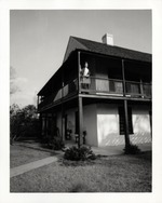Northwest corner of the Arrivas House from the side yard with Jean Babich on the second-story balcony, looking Southeast, 1970