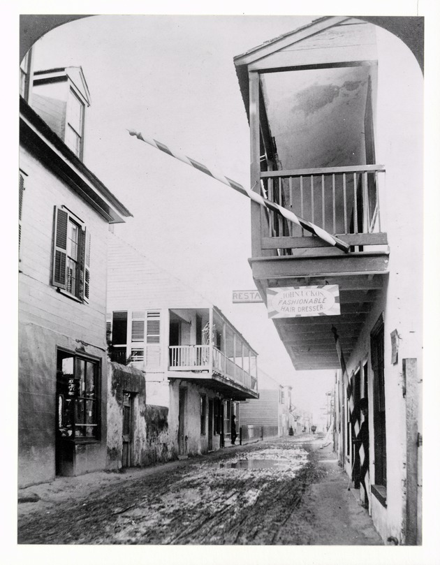 Historic view down St. George Street with the Arrivas House (with balcony) on the left and the Spanish Inn (De Mesa Sanchez House) on the right, looking North, 1886