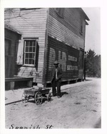 Man standing on Spanish Street with wagon near the intersection with Orange Street, looking Northwest