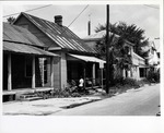 Boy mowing the lawn and woman on the porch in a house on Spanish Street (Block 16 Lot 21) from near Cuna Street, looking Northwest