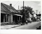 View down the West side of Spanish Street with boy mowing the lawn and woman on the porch in a house on Spanish Street (Block 16 Lot 21), near Cuna Street, looking Northwest