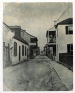 Historic photo of St. George Street taken from the street standing in front of the Poujoud-Slater House, with Benet Store on the immediate left, and Benet House on the immediate right, the intersection with Cuna Street is clearly visible, looking North