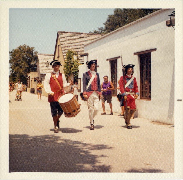 Reenactors in period dress marching on St. George Street in front of the Florencia House, looking Northeast