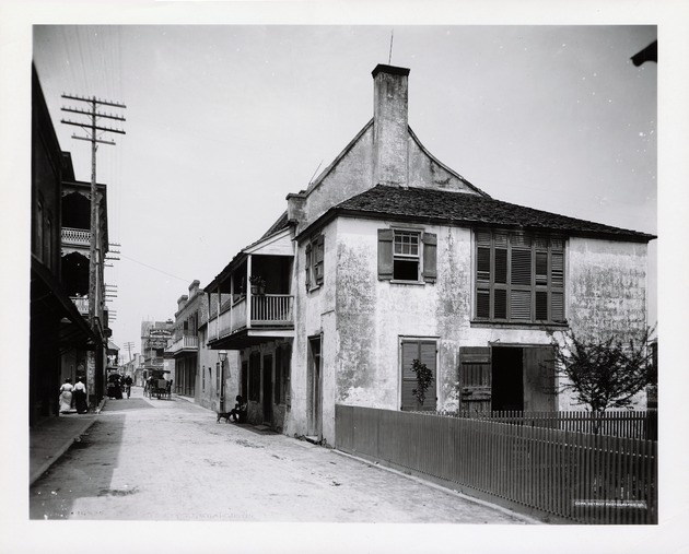 Historic view of the Benet House with a man sitting in the doorway petting a dog from St. George Street, looking North, ca. 1895