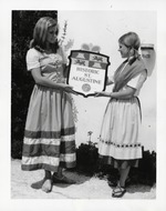 [1970] Sydney B. Raulerson (left) and Linda Dean (right) hold up a plaque for Historic St. Augustine, 1970